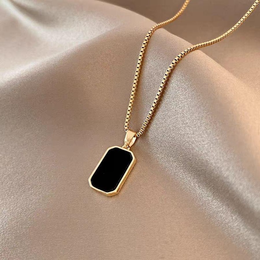 Goldfarbene Kette mit schwarzem Rechteck-Anhaenger